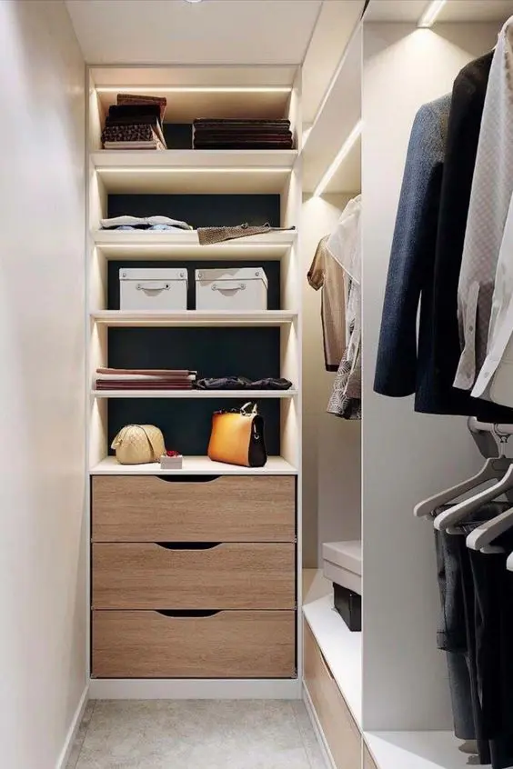 a tiny narrow closet with open lit up shelves, drawers and open storage units is a lovely space to be in