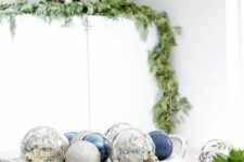 a tray with silver and blue Christmas ornaments is a beautiful centerpiece that will make your table chic