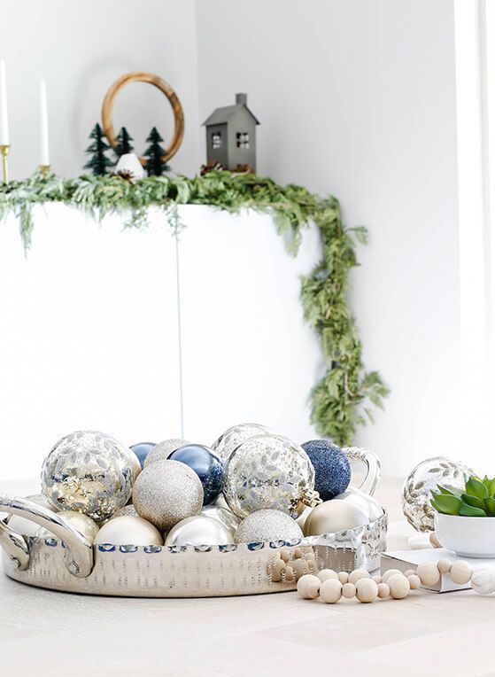 a tray with silver and blue Christmas ornaments is a beautiful centerpiece that will make your table chic
