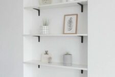 an airy minimalist space with built-in niche shelves with various decor and potted greenery is a lovely one