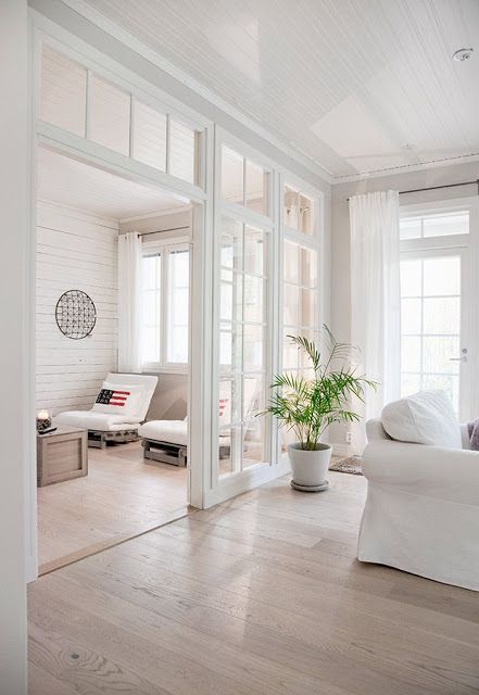 an airy white space with a glazed wall and transom windows to connect the rooms and provide both of them with natural light