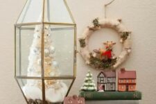 an elegant Christmas terrarium with faux snow, a white bottle brush Christmas tree with pearly ornaments