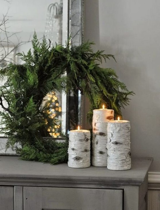 an evergreen wreath with tree stump candleholders with candles are a nice Christmas combo