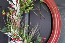 an oval picture frame decorated with faux greenery, silver twigs and branches, berries and a large calligraphy bow for vintage Christmas decor