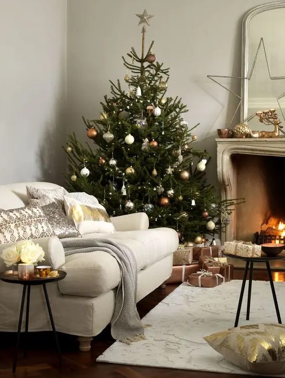 copper, silver and gold ornaments of various shapes make the tree very chic and don't require any additional decor here