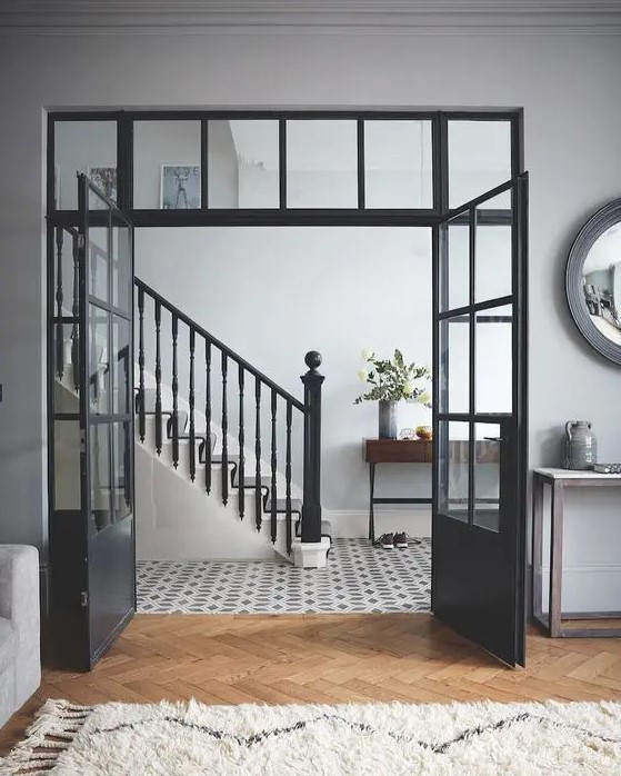 elegant black doors plus a transom window on top let the foyer receive more natural light and add interest to the space