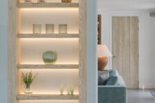 niche shelves of whitewashed wood and with built-in lights are amazing, and lights highlight everything that’s on display