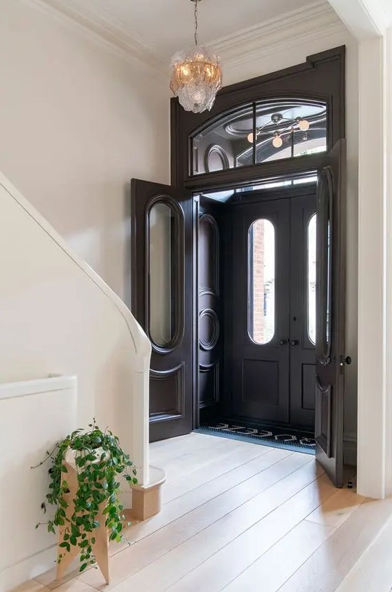 vintage black doors with glass and transom windows are a great combo for a chic and stylish space, they add more natural light to the entry