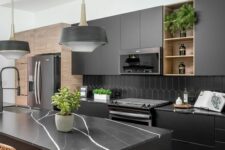 06 a modern matte black kitchen with a hex tile backsplash, black marble countertops, black pendant lamps and woven chairs