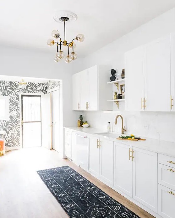 a mid-century modern kitchen done in white, with brass handles and faucets looks extremely elegant and chic