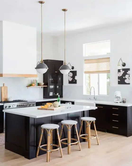 a black and white kitchen with black cabinets, white walls, countertops and a backsplash and a matching black and white kitchen island