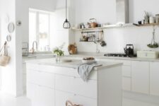 16 a white Scandinavian kitchen with sleek cabinets and white stone countertops, a black pendant lamp for an accent