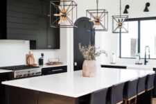 17 a black farmhouse kitchen with shaker cabinets, a beadboard hood, a large kitchen island with lots of stools
