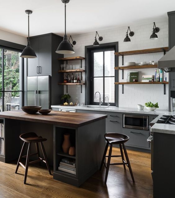 a chic kitchen with grey cabinets, open shelves, white countertops, a black kitchen island with a butcherblock countertop