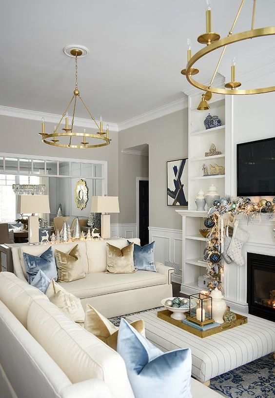 a chic and glam living room done in neutrals, with pink and gold accents, gold chandeliers make a statement here