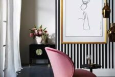 21 a sophisticated living room with a black and white accent wall, a pink chair and a pretty artwork and refined furniture