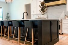 24 a creative black and white kitchen with shaker cabinets, a large kitchen island, a statement black hood and stools