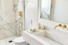 27 a breathtaking white marble bathroom with marble in the shower space, a white slab sink, white appliances and gold fixtures