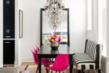 27 a chic dining space with a statement mirror, a black table, fuchsia chairs, a striped bench and a chic and bold chandelier