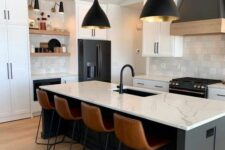 29 a modern black and white kitchen with white shaker cabinets, a black kitchen island, white countertops and a backsplash, black lamps