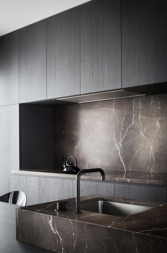 a minimalist sleek grey kitchen with a brown marble backsplash and countertops plus a matching sink for a wow effect