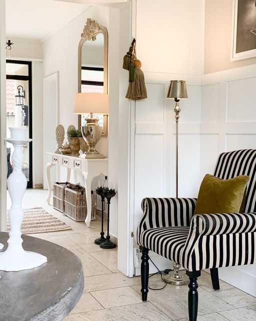 a sophisticated black and white striped chair with a mustard pillow is a gorgeous addition to the space