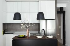 36 a small black and white kitchen with sleek cabinets, a concrete backsplash, a black kitchen island and black lamps over it