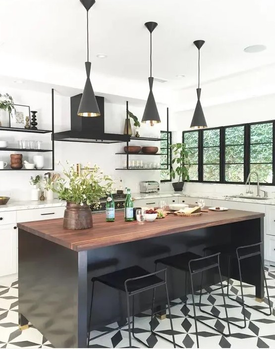 a white farmhouse kitchen accented with a black mosaic floor, a black kitchen island and black pendant lamps
