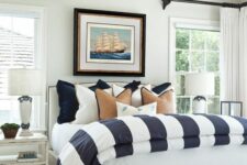 41 a beach bedroom with a whitewashed bed with striped bedding, shabby chic nightstands and a lovely bench plus a ship artwork