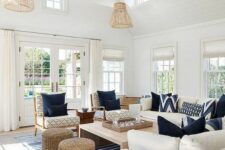 42 a beachy living room with creamy seating furniture, printed chairs, a low coffee table, jute poufs and layered rugs including a striped one