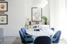 44 a gorgeous dining space with a quirky credenza, an oval table and blue chairs, a statement geometric rug and a cool chandelier