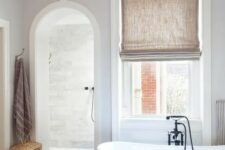 53 a contemporary bathroom with an arched doorway inviting to the shower space for more eye-catchiness