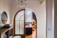 55 a modern space with large arched doors with frosted glass that highlight the style and match the floors with their stain