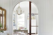 56 a refined vintage-inspired house with a double-height arched doorway and a rich-stained arched glass pocket door