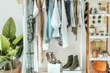 a boho makeshift closet with a white clothes and shoe rack, a tall stand with accessories and a garland with moon phases over it