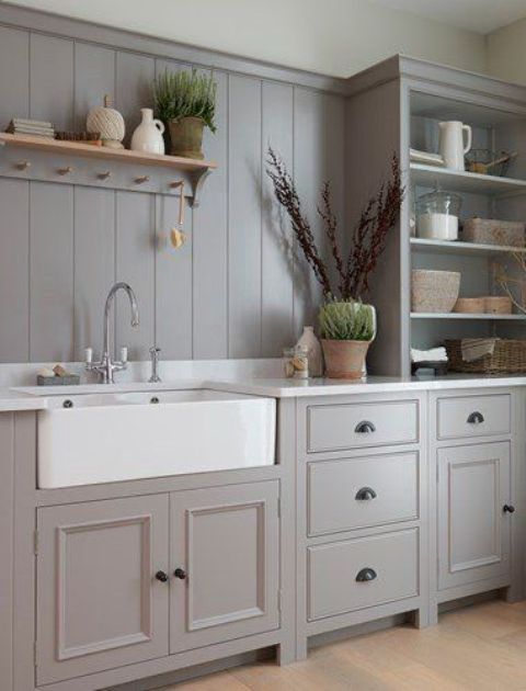 a chic grey kitchen with shaker style cabinets, a matching beadboard backsplash and a white stone countertops