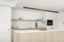 a chic neutral kitchen with stained and creamy cabinets, an open shelf, a curved and ribbed kitchen island