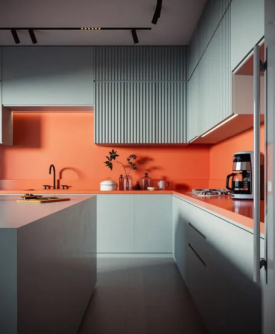 a colorful kitchen with slate blue plain and ribbed cabinets, an orange backsplash and countertops plus black fixtures