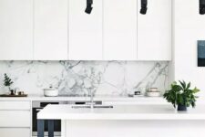 a contemporary white kitchen with a marble backsplash, black stools, lamps and legs, potted greenery to refresh the space