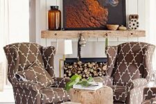 a cozy nook by the fireplace with firewood, printed chairs, a reclaimed wood mantel, a bold artwork and rough wood stools