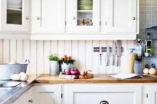 a creamy kitchen with shaker cabinetry, butcherblock countertops, a creamy beadboard backsplash and blue tiles
