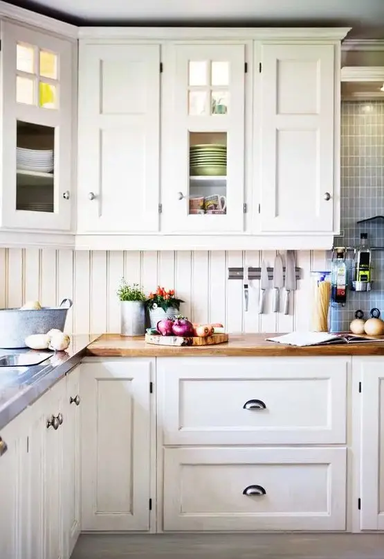 a creamy kitchen with shaker cabinetry, butcherblock countertops, a creamy beadboard backsplash and blue tiles