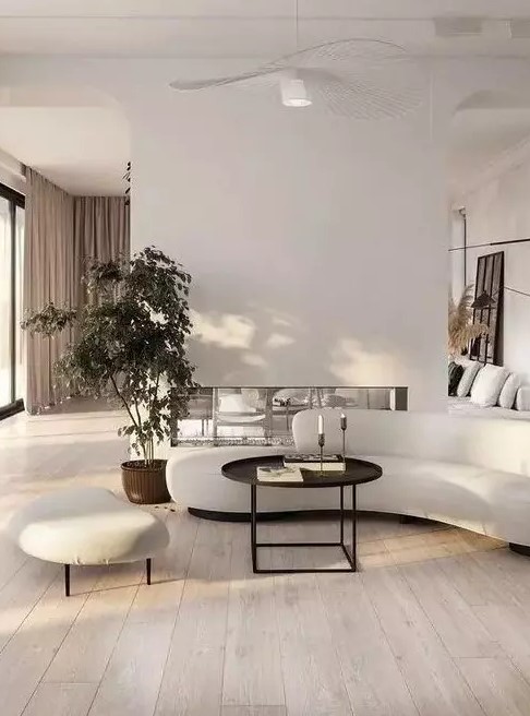 a fabulous contemporary living room with a built-in fireplace, a curved sofa and a footrest, a black coffee table, potted plants