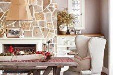 a farmhouse dining space with a fireplace clad with stone, a rough wood ceiling, a built-in storage unit, a rough wood dining set plus an elegant wingback chair