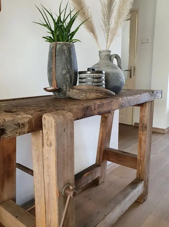 a large rough wood console table with a very rustic design is a gorgeous addition to a farmhouse space or a boho one