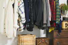 a makeshift closet made of a couple of dressers, baskets, a copper railing for hanging clothes is a great idea