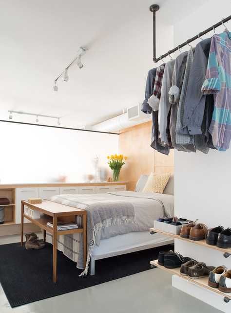 a makeshift closet with a black metal railing and open shoe shelves is easy and simple to realize yourself