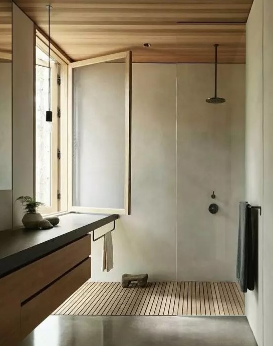 a minimalist bathroom clad with concrete, a floating wood and concrete vanity, a window and a wooden floor and ceiling