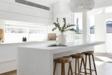 a minimalist white kitchen with sleek cabinets, a window backsplash, a large kitchen island, stained stools