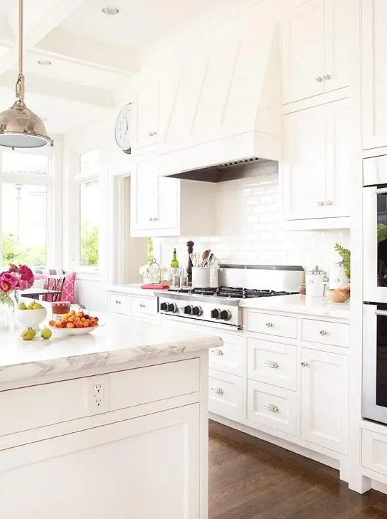 a modern farmhouse kitchen done in creamy shades with marble countertops looks very chic and welcoming